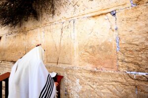 אדם מתפלל ליד הכותל המערבי בירושלים.